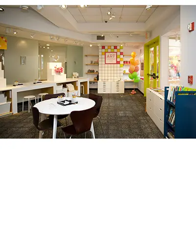 interior photo of the art learning lab featuring worktables and colorful decorations